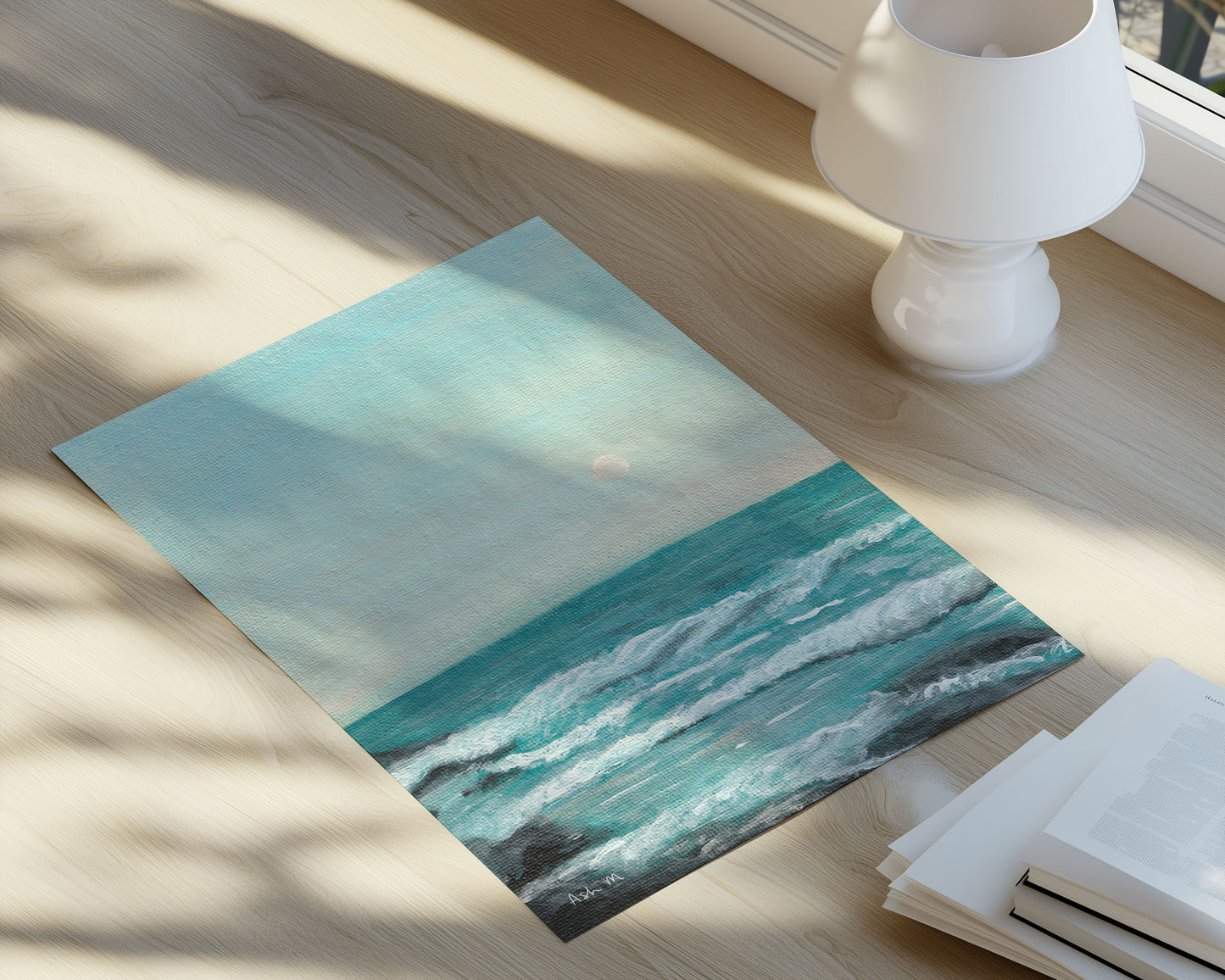 Ocean painting laid out on a wooden floor, natural light beaming in. 